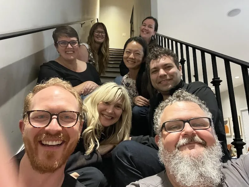 Adam Cuppy, Jim, Suzan Bond, Lar van der Jagt, Chelsea Kaufman, Joyce Hu, Vanessa Bastien, Chantelle Isaacs Eight smiling people seated on the stairs in a group photo.