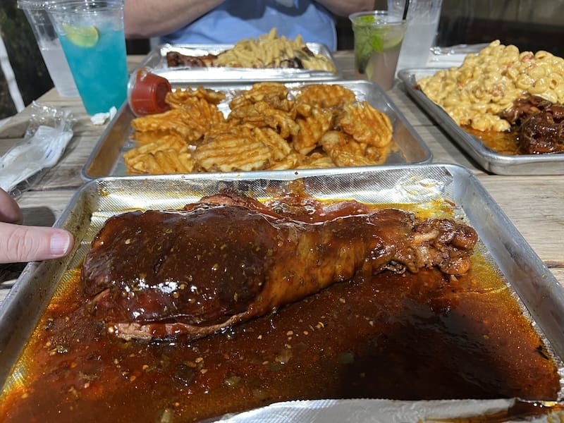 A gorgeous turkey leg glazed in a Hennessy sauce. This thing was nearly 12" long! Waffle fries and other turkey legs mounded in Alfredo and Crawfish Mac & Cheese are in the background.
