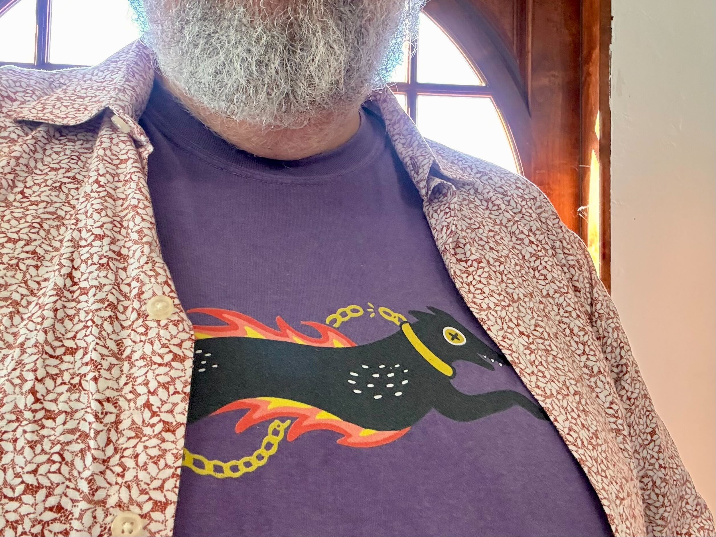 Picture of Jim wearing a shirt with Uleash Your Spark design on a purple shirt 