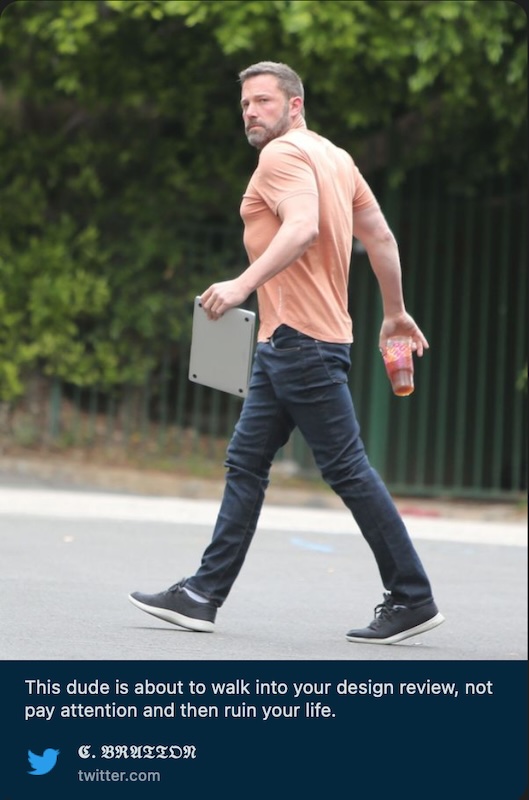 A meme showing Ben Affleck walking, with a laptop in hand, while staring down a photographer.